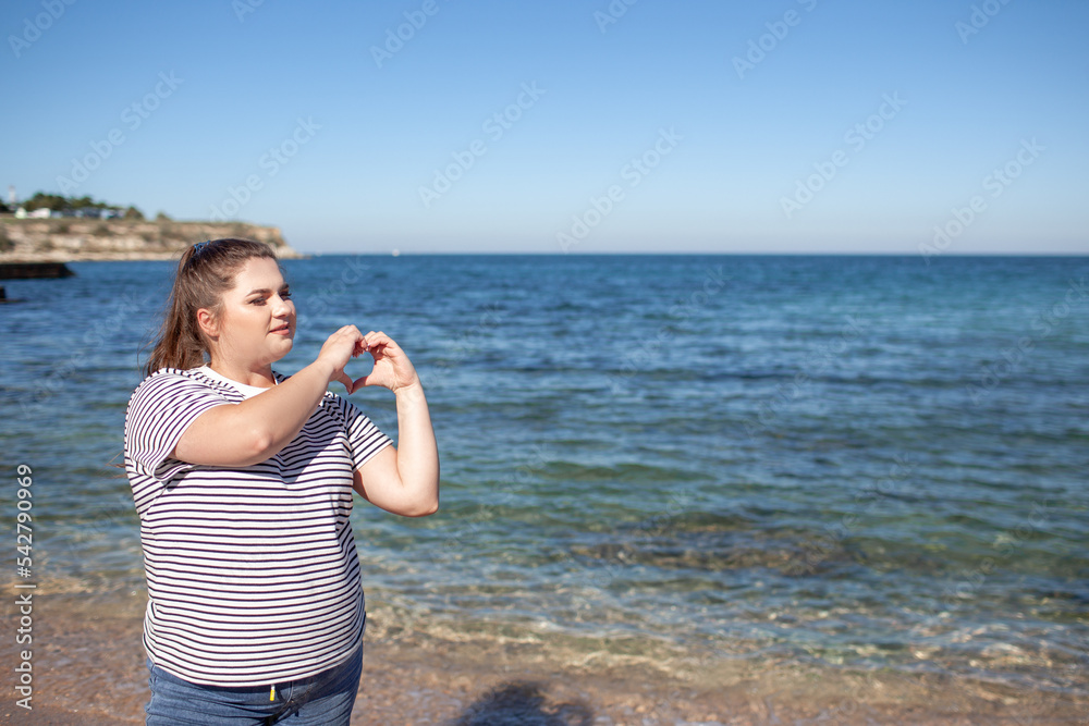 Beautiful plus size woman walking in the beach, resting and enjoy the moment to be alone and meditate near the sea or ocean in the beach. Overweight woman dressed jeans and t-shirt Beautiful plus size woman walking in the beach, resting and enjoy the moment to be alone and meditate near the sea or ocean in the beach. Overweight woman dressed jeans and t-shirt
