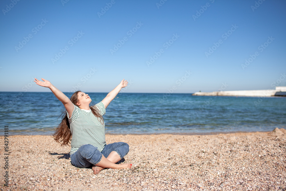 Beautiful plus size woman walking in the beach, resting and enjoy the moment to be alone and meditate near the sea or ocean in the beach. Overweight woman dressed jeans and t-shirt Beautiful plus size woman walking in the beach, resting and enjoy the moment to be alone and meditate near the sea or ocean in the beach. Overweight woman dressed jeans and t-shirt