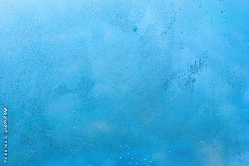 Abstract wet blue background. Rainy window view. Rain drops on the window glass.