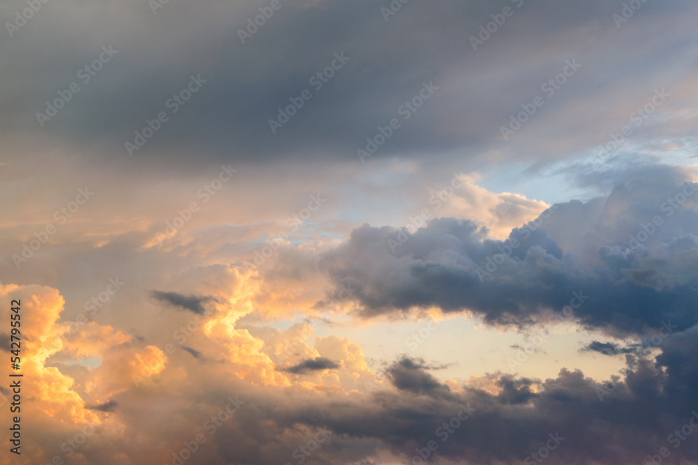 Summer evening sky in the picturesque clouds, lit by the rays of the setting sun.