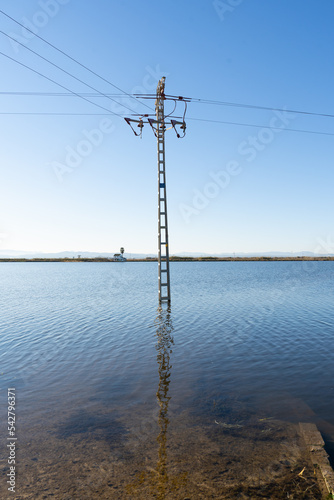 Electrical tower located in a flooded farm field in a rural area