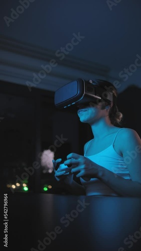 woman in vr glasses plays virtual reality game in metaverse universe and experiences different emotions,colorful illuminated vertical video
