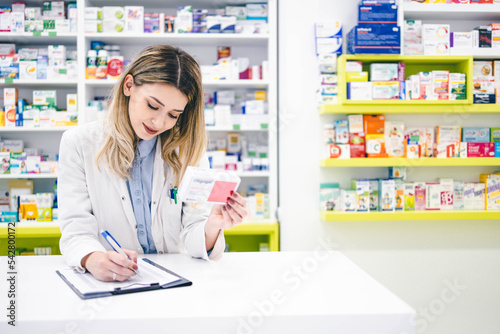 Portrait of young female pharmacist worker in pharmacy store 
