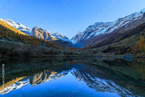Grundsee Lake in the Fafleralp Valley at the sunrise time with reflection of the surrounding Alps mountain peaks and the Long Glacier