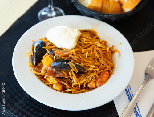Traditional Catalan pasta paella (fideua) with shrimps and mussels served with piquante aioli sauce © JackF