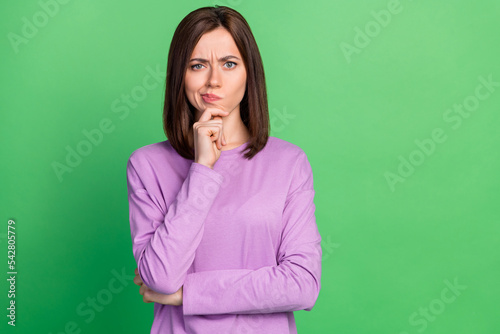 Photo of young attractive smart thoughtful lady touch chin minded choosing new shoes price isolated on green color background