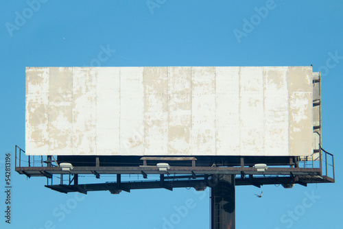 Damaged old billboard sign with texture in a clear blue sky © John Hanson Pye