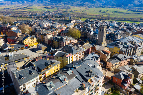 Panoramic aerial view of Puigcerda townscape overlooking medieval bell tower of ruined Santa Maria church in sunny autumn day, Girona, Spain photo