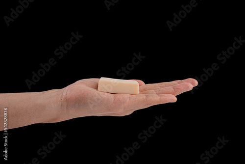 Hand holding soap on black background