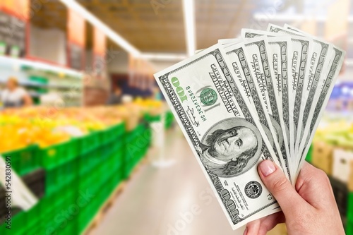 Money banknotes on background of food in market.