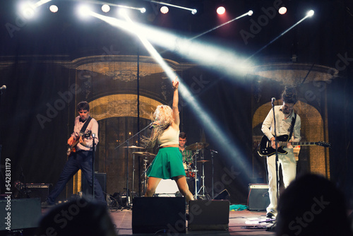 Rock band playing on the concert stage at summer night	