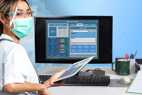 Female doctor working on electronic medical record with a desktop computer. photo