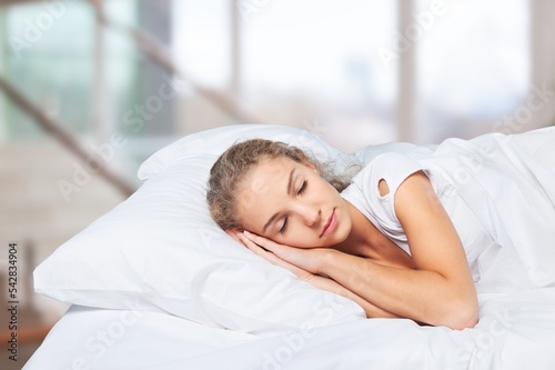 Young sleeping woman in bed, hotel concept