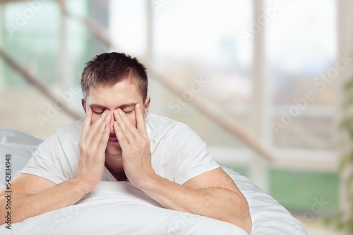 Young sleeping man in bed, hotel concept