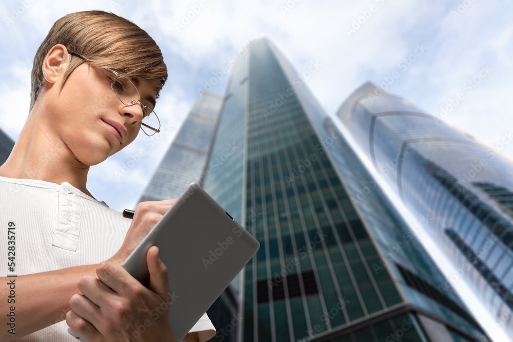 Smiling businessman walking on city background Smiling businessman walking on city background