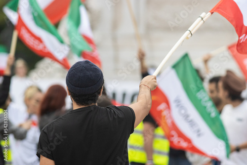 People waving flags at the rally dedicated to the incident in Iran
