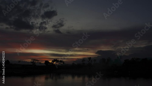 cinematic footage colorful sunset at tropical island with few silhouette boat pass the lake 