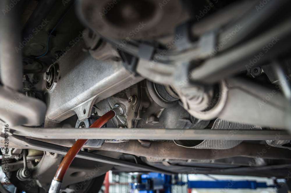 Auto Mechanic filling car rear differential gear oil. - obrazy, fototapety, plakaty 