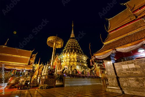 Gold pagoda and buddha statue in Wat Doi Suthep temple at night