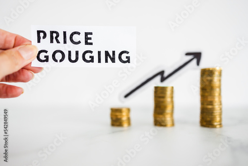 Canvastavla hand holding Price Gouging text in front of growing stacks of coins, symbol of e