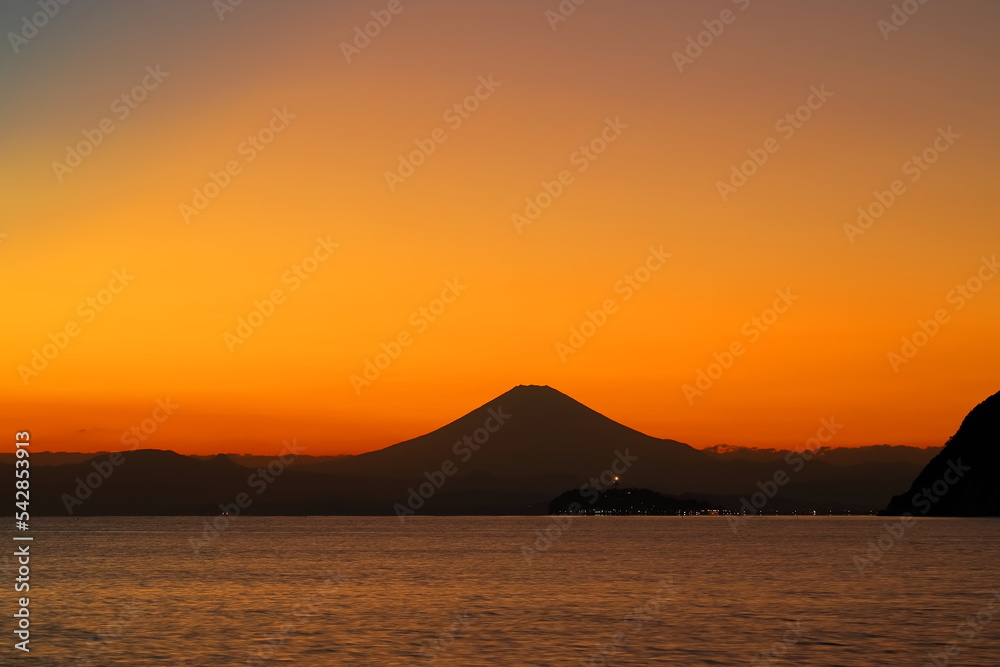 夕焼けに染まる空に浮かび上がる富士山と江ノ島のシルエット