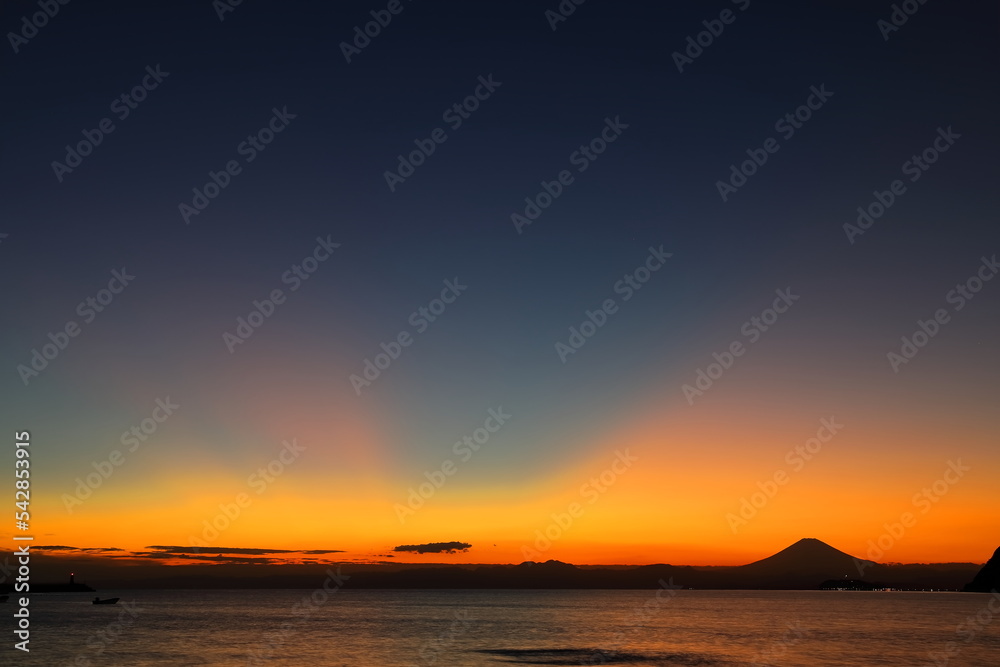 日没後にオレンジ色に染まる空と富士山のシルエット