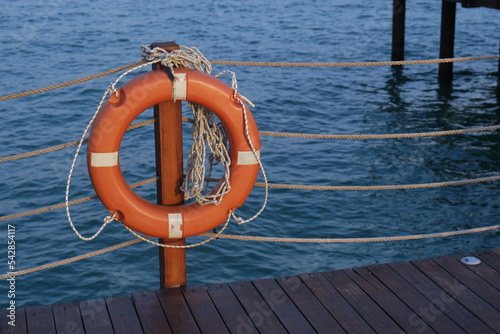Lifebuoy tied to a pier against the backdrop of the sea