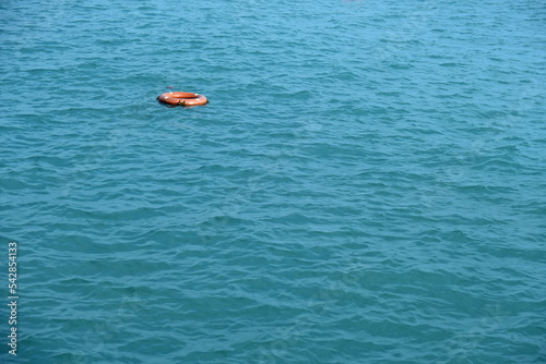 Lifebuoy floating alone in the sea. Turquoise sea and lifeline.