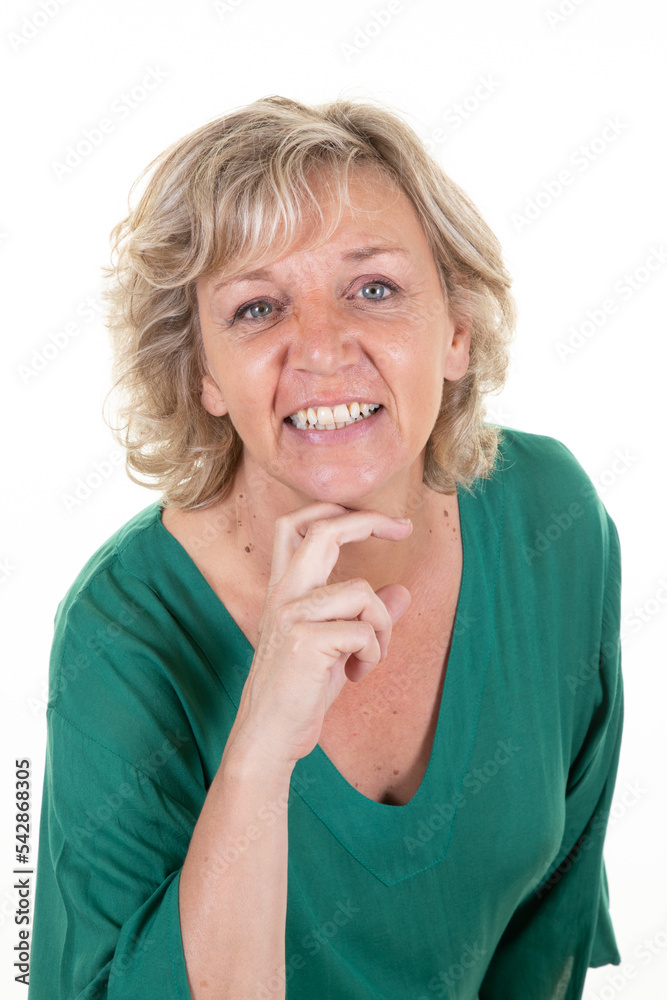 Portrait of senior woman with green shirt hand under chin in white studio background Portrait of senior woman with green shirt hand under chin in white studio background