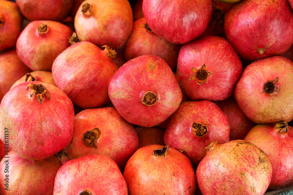 Juicy ripe pomegranate fruits on the market counter for juice. Pomegranate harvest on agricultural farm, vitamins, fruits, tropics concept. Juicy ripe pomegranate fruits on the market counter for juice. Pomegranate harvest on agricultural farm, vitamins, fruits, tropics concept.