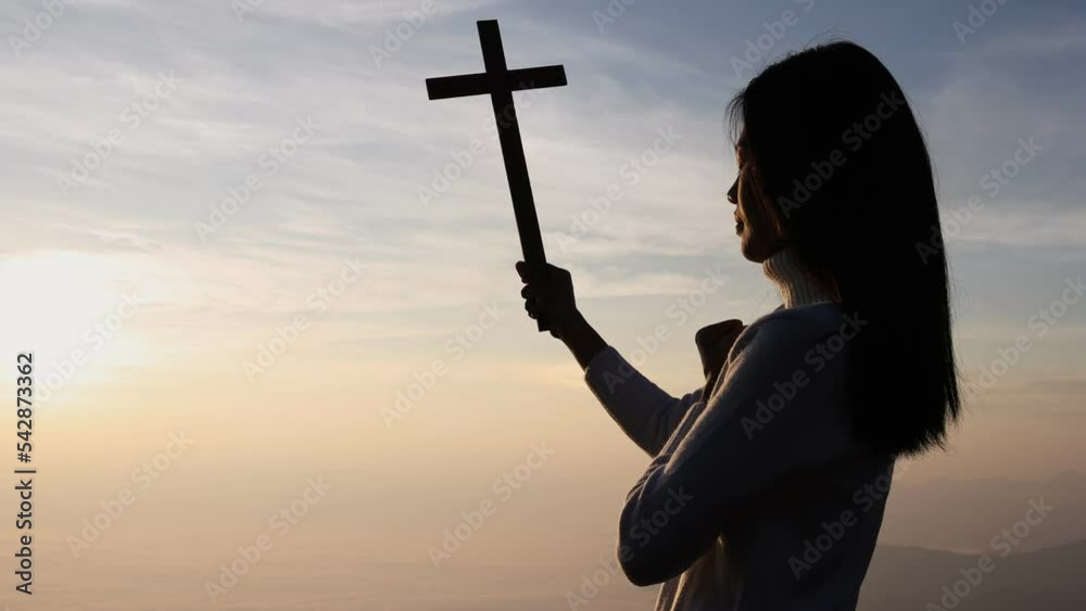 Silhouette of woman hands praying with cross in nature sunrise ...