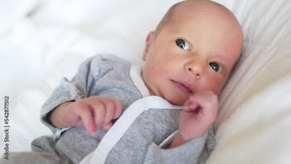 newborn. baby newborn a close-up lies looking at the camera in the hospital maternity hospital. happy family baby dream concept. cute newborn lifestyle baby in gray clothes newborn. baby newborn a close-up lies looking at the camera in the hospital maternity hospital. happy family baby dream concept. cute newborn lifestyle baby in gray clothes