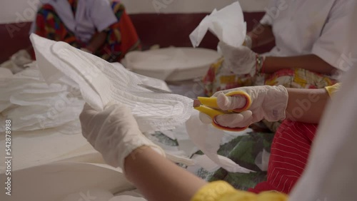 Women making and cutting Sanitary Napkin in mini factory photo