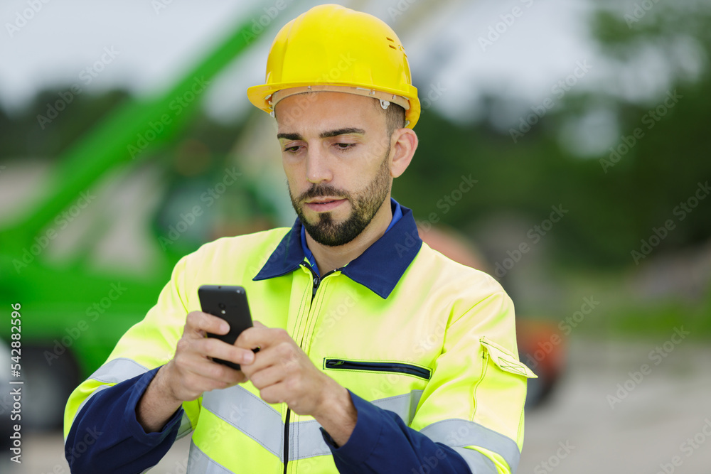 manual worker using smartphone to send message manual worker using smartphone to send message