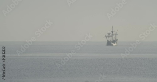 Ferdinand Magellan Nao Victoria carrack boat replica with spanish flag sails in the mediterranean at sunrise in calm sea in slow motion 60fps photo