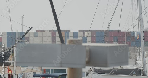 Ferdinand Magellan Nao Victoria carrack boat replica with spanish flag enters wharf in Valencia with containers in the background in slow motion 60fps photo