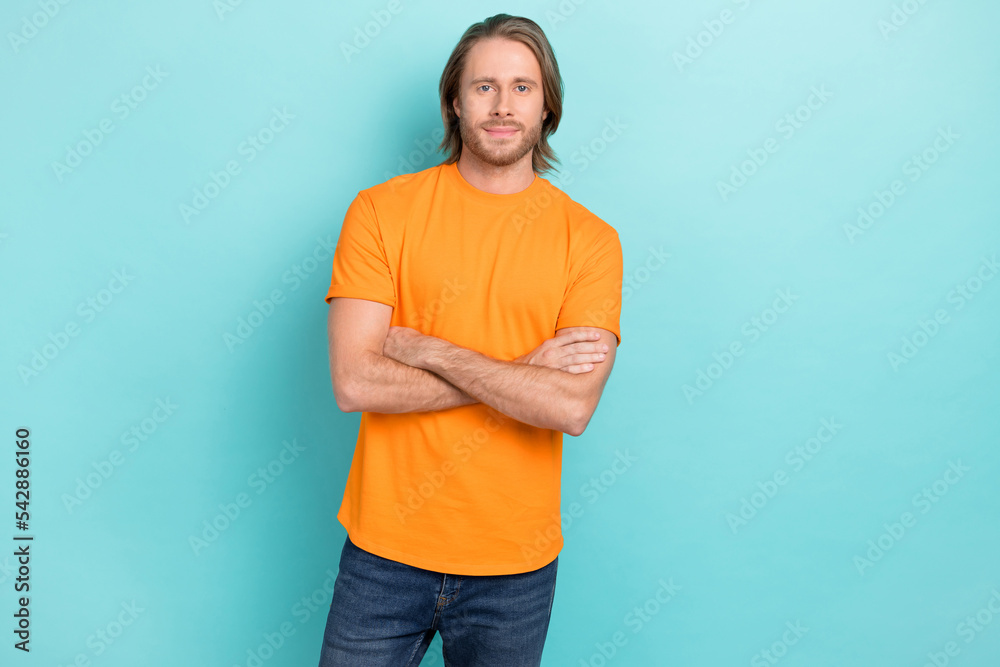 Fototapeta premium Portrait photo of young handsome confident man student wear orange t-shirt folded arms professional designer isolated on blue color background