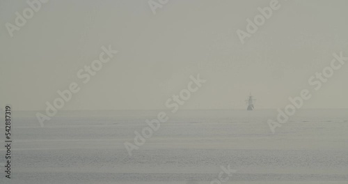 Ferdinand Magellan Nao Victoria carrack boat replica sails in the distance in the mediterranean at sunrise in calm sea in slow motion 60fps photo