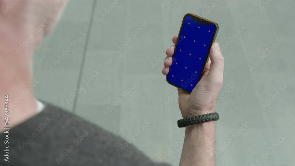 Man picking up calling smart phone iPhone blue green screen replacement tracker marker tracking screens right hand holding cellphone watching app tiktok trending modern technology stock social media