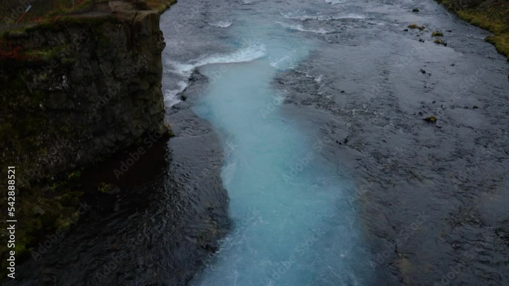 Aerial tilt up shot of natural blue colored wild river in Iceland,Europe - Beautiful nature landscape during cloudy day