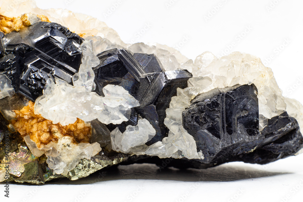 A crystal and stone cluster with clear white quartz, silver metallic pyrite and black tourmaline surrounded by matrix macro close up isolated on a white surface background