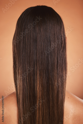 Beauty, hair care and woman with a balayage in a studio from the back with a beautiful hairstyle. Wellness, natural and model with long, straight and clean hair style isolated by a orange background.