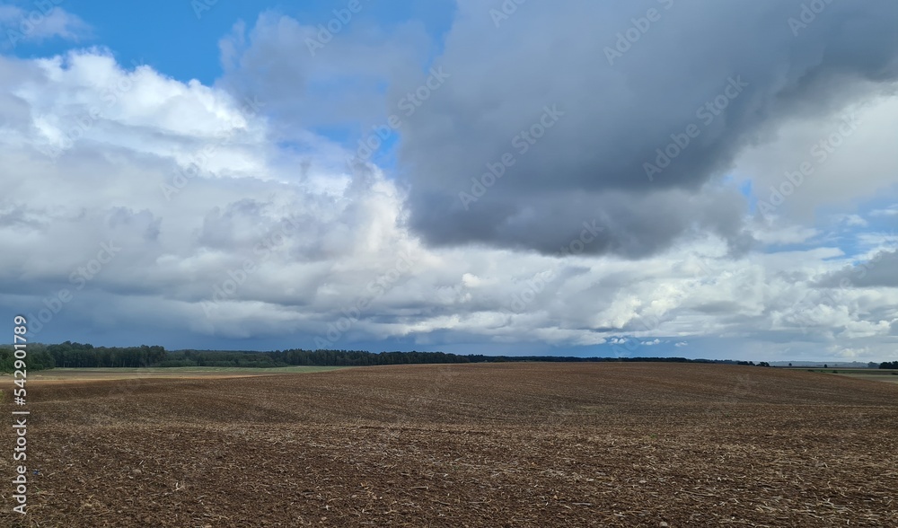 Cloudy gloomy sky over the field where the wheat harvest was harvested Cloudy gloomy sky over the field where the wheat harvest was harvested