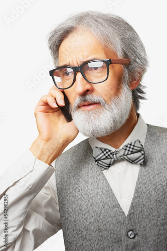 elderly man with a gray beard talking on a mobile phone isolated on white background