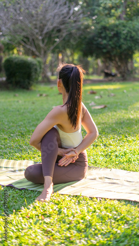 Asian Beauty and healthy woman exercise and doing meditation of yoga on exercise mat in the morning exercise in the park. - fitness, sport, yoka concept. photo