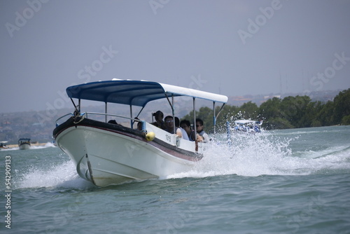 tourist boat that runs over the sea. white foam formed around it. some of the passengers seemed to enjoy the ride