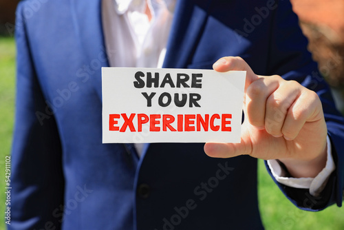 Vászonkép Man holding card with phrase Share Your Experience outdoors, closeup