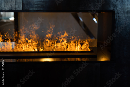 stylish artificial fireplace behind glass