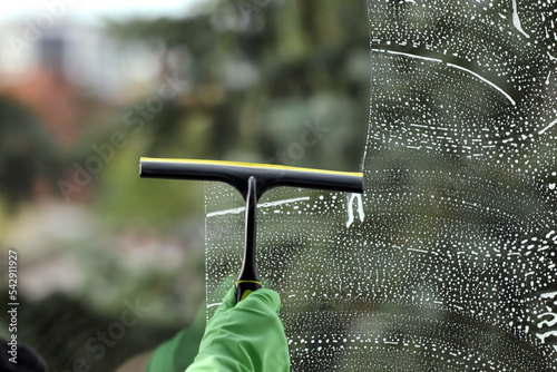 Cuadro en lienzo Woman cleaning glass with squeegee indoors, closeup