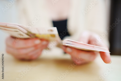 a woman holds in her hands and recalculates Russian banknotes of 100 rubles. 